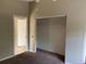 Bedroom with a closet featuring metal storage, a door to an adjacent room, and neutral carpeting at 2918 E Waters Ave, Tampa, FL 33604