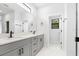 Bathroom featuring double vanity, gray cabinets, modern fixtures, and large mirrors at 4080 Baynes Rd, North Port, FL 34288