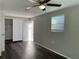 Cozy bedroom with dark wood floors, a ceiling fan, and a well-lit closet space for storage solutions at 3522 Windham Dr, Holiday, FL 34691