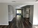 Spacious living area with elegant dark wood floors and neutral-toned walls leading to an outdoor patio at 3522 Windham Dr, Holiday, FL 34691