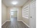 Well-lit hallway featuring neutral walls, built in shelving, and modern gray wood-look flooring at 3645 6Th S St, St Petersburg, FL 33705
