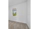 Bright bedroom features neutral carpet, white walls, baseboards and window to a green outdoor space at 7338 N Ficus Tree, Punta Gorda, FL 33955