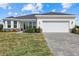 Charming single-story home with a well-manicured lawn and a paved driveway leading to a two-car garage at 7338 N Ficus Tree, Punta Gorda, FL 33955