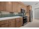 Spacious kitchen with wood cabinets, stainless steel appliances, decorative backsplash, and stone countertops at 7338 N Ficus Tree, Punta Gorda, FL 33955