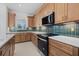 Stylish kitchen boasting stainless steel appliances, elegant wood cabinetry, and decorative backsplash tiles at 7338 N Ficus Tree, Punta Gorda, FL 33955