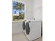 Bright laundry room featuring washer/dryer, shelving, and a window with a tropical view at 7338 N Ficus Tree, Punta Gorda, FL 33955