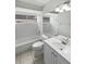 Clean bathroom with white tiled shower and sink and a large mirror at 8080 Spanish Oak Dr, Spring Hill, FL 34606