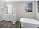 Elegant bathroom featuring a soaking tub, double vanity sinks, and modern fixtures at 8080 Spanish Oak Dr, Spring Hill, FL 34606