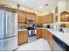 Well-lit kitchen with stainless steel appliances, ample counter space, and oak cabinets at 11805 Castine St, New Port Richey, FL 34654