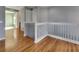 Upstairs hallway with hardwood floors and white bannister at 1181 Burgos Dr # 406, Sarasota, FL 34238