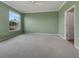 A large, light-filled room with plush carpeting, a ceiling fan, and a view of the outdoors at 1181 Burgos Dr # 406, Sarasota, FL 34238