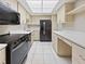 View of the kitchen, featuring stainless steel appliances, light wood cabinets, and tile flooring at 612 Bird Bay S Dr # 113, Venice, FL 34285