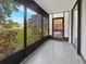 Enclosed lanai featuring sliding windows overlooking a beautifully landscaped yard with building in background at 612 Bird Bay S Dr # 113, Venice, FL 34285
