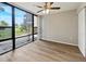 Living room showing hardwood floors, ceiling fan, and large windows overlooking exterior landscaping at 612 Bird Bay S Dr # 113, Venice, FL 34285