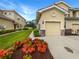 Townhome featuring an attached garage, lush landscaping, and a paver driveway at 8110 Enclave Way # 101, Sarasota, FL 34243