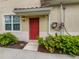 Inviting front entrance featuring a bright red door and well-maintained landscaping at 8110 Enclave Way # 101, Sarasota, FL 34243