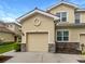 Charming townhome featuring an attached garage, neutral stucco and stone accents, and a red-tile roof at 8110 Enclave Way # 101, Sarasota, FL 34243