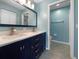 Bathroom with double sink vanity, framed mirror and a doorway leading to the toilet and shower at 6507 Stone River Rd # 310, Bradenton, FL 34203
