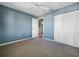 Minimalist bedroom with blue accent wall, closet space, ceiling fan, and neutral carpet, offering a calming atmosphere at 6507 Stone River Rd # 310, Bradenton, FL 34203