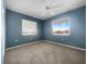 Bright bedroom with a ceiling fan, carpet flooring, and two windows for natural light at 6507 Stone River Rd # 310, Bradenton, FL 34203