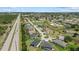 Expansive aerial shot highlights neighborhood near highway with many single-Gathering homes and ample green space at 7443 S Seagrape Rd, Punta Gorda, FL 33955