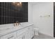 Modern bathroom vanity with marble countertop, gold fixtures, and vertical tile backsplash at 7443 S Seagrape Rd, Punta Gorda, FL 33955