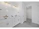 Modern bathroom featuring double sink vanity, white countertops, and unique vertical tiled wall at 7443 S Seagrape Rd, Punta Gorda, FL 33955