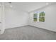 Bright bedroom with gray carpet, white walls, baseboards, trim, and two sunny windows at 7443 S Seagrape Rd, Punta Gorda, FL 33955
