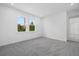 Bright bedroom with gray carpet, white walls, trim, and two sunny windows at 7443 S Seagrape Rd, Punta Gorda, FL 33955