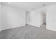 Bright bedroom with gray carpet, white walls, trim, and an open doorway at 7443 S Seagrape Rd, Punta Gorda, FL 33955