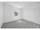 Bright bedroom with gray carpet, white walls, baseboards, trim, and a sunny window view at 7443 S Seagrape Rd, Punta Gorda, FL 33955