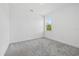 Bedroom with plush carpet flooring, modern window, and white walls at 7443 S Seagrape Rd, Punta Gorda, FL 33955