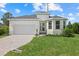 Charming one-story home featuring a two-car garage, landscaped front yard, and neutral color palette at 7443 S Seagrape Rd, Punta Gorda, FL 33955
