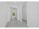 Neutral hallway with gray tile flooring and views into rooms filled with natural light at 7443 S Seagrape Rd, Punta Gorda, FL 33955