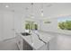 Kitchen island with marble countertop, stainless steel sink, dishwasher, and modern hanging lights at 7443 S Seagrape Rd, Punta Gorda, FL 33955