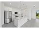 Modern kitchen with white cabinetry, stainless steel appliances, marble countertops, and stylish pendant lighting at 7443 S Seagrape Rd, Punta Gorda, FL 33955