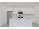 Modern kitchen with white cabinetry, stainless appliances, marble countertops, and three pendant lights above the island at 7443 S Seagrape Rd, Punta Gorda, FL 33955