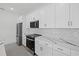 A modern kitchen featuring white cabinets, stainless steel appliances, and marble countertops at 7443 S Seagrape Rd, Punta Gorda, FL 33955