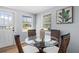 Bright dining area with a glass table, four chairs, and natural light from the windows at 1805 Rita St, Sarasota, FL 34231