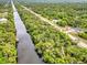 Breathtaking aerial view featuring a canal running alongside a house with lush greenery at 18399 Hillsborough Blvd, Port Charlotte, FL 33954