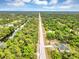 Expansive aerial view of a home near a long road and scenic canal amidst lush green surroundings at 18399 Hillsborough Blvd, Port Charlotte, FL 33954