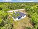 Aerial view showcases modern home nestled among lush trees and greenery at 18399 Hillsborough Blvd, Port Charlotte, FL 33954