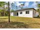 A spacious backyard features a stucco home with a dark roof at 18399 Hillsborough Blvd, Port Charlotte, FL 33954