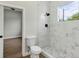 Bathroom featuring a toilet and walk-in shower with marble surround at 18399 Hillsborough Blvd, Port Charlotte, FL 33954