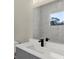 Modern bathroom features a sleek, white vanity, black fixtures, and a decorative mirror at 18399 Hillsborough Blvd, Port Charlotte, FL 33954