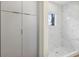 Elegant bathroom showcasing a walk-in shower with marble-like tiles and a storage cabinet at 18399 Hillsborough Blvd, Port Charlotte, FL 33954