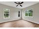 Bright bedroom featuring wood-style flooring and multiple windows for natural light at 18399 Hillsborough Blvd, Port Charlotte, FL 33954