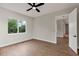 Well-lit bedroom featuring wood-style flooring, ceiling fan and walk-in closet at 18399 Hillsborough Blvd, Port Charlotte, FL 33954
