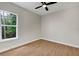 A clean and bright bedroom with beautiful hardwood flooring and a large window at 18399 Hillsborough Blvd, Port Charlotte, FL 33954