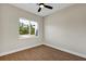 A simple bedroom features a window and hardwood floors at 18399 Hillsborough Blvd, Port Charlotte, FL 33954